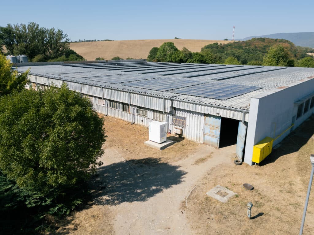 Aerial view of the farm building in Žarnov with photovoltaic panels covering the roof