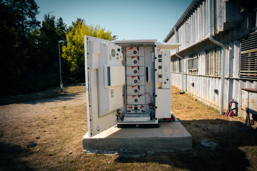 Open battery storage cabinet showing the stacked battery modules at the farm in Žarnov