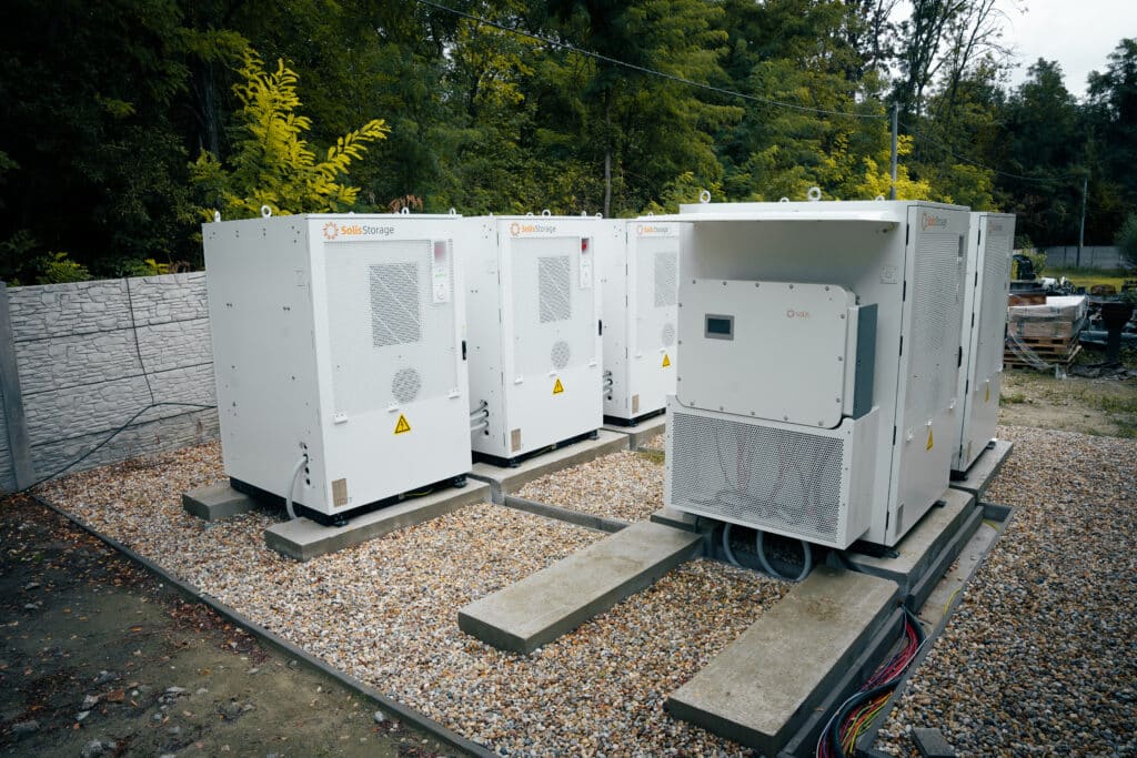 Row of Solis Storage battery cabinets on concrete bases at the Gabčíkovo research station, one door open